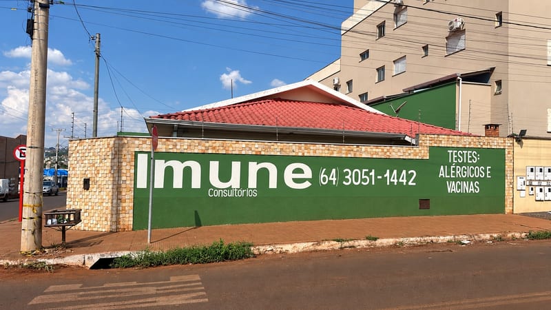 Muro lateral da Clínica Imune com o telefone (64) 3051-1442 e a indicação de testes alérgicos e vacinas, no Setor Morada do Sol, Rio Verde
